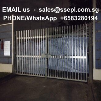 Metal sliding gate closed at night with overlaid sales contact email and phone/WhatsApp numbers on top.